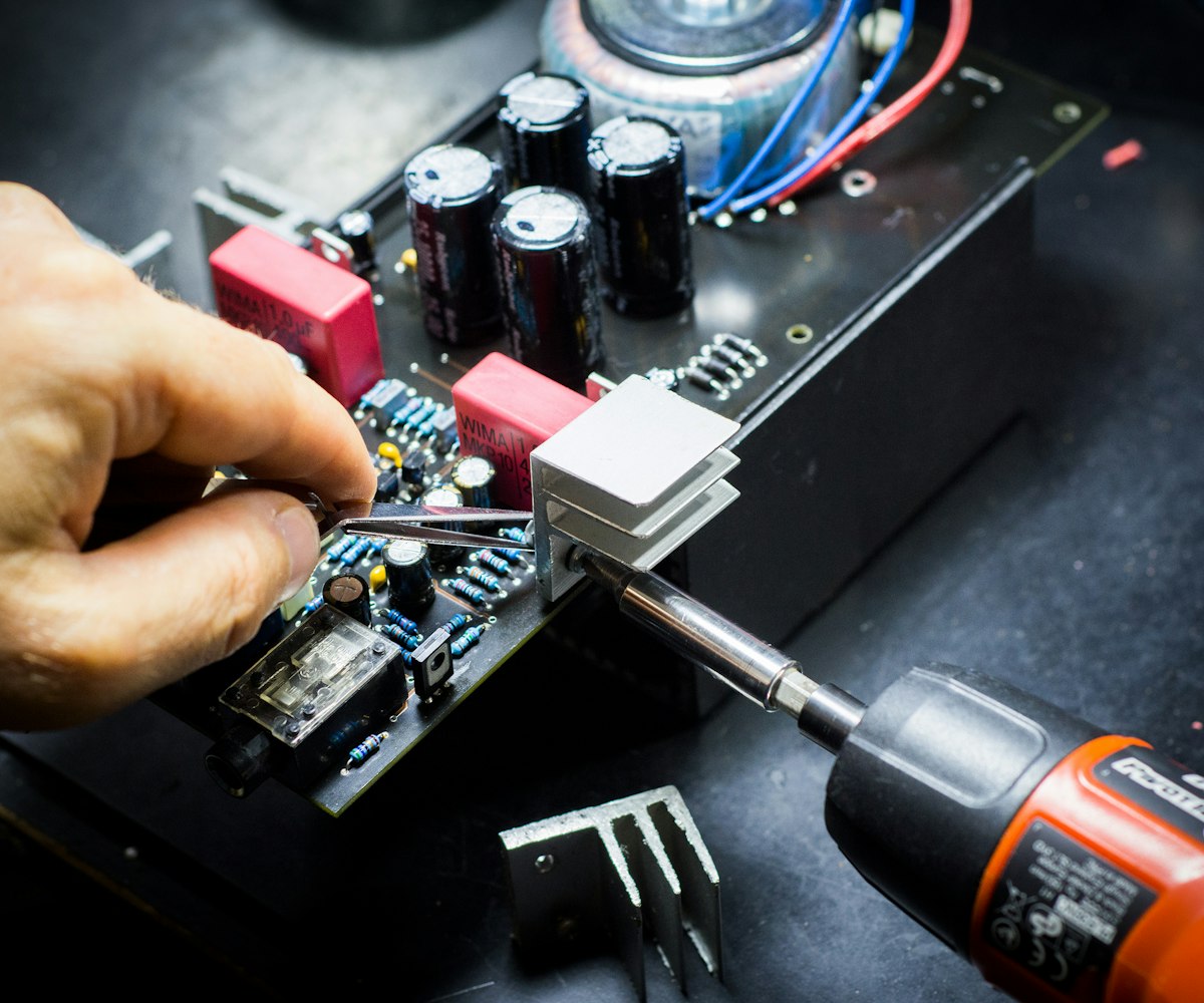 Tweezers and a soldering iron on an electronics board